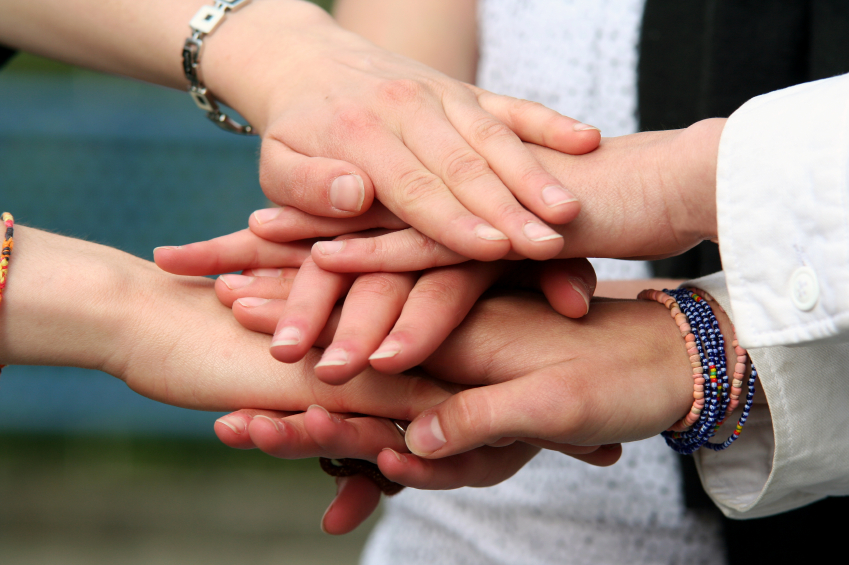 Several hands stacked one on another